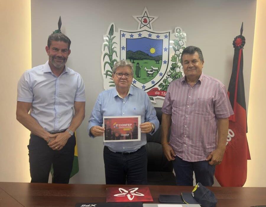 Concurso de Cruz do Espírito Santo é apresentado em registro com representantes municipais diante do brasão da cidade